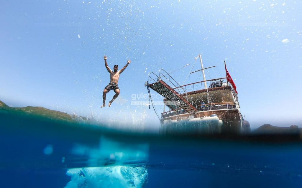 man-jump-on-gulet-blue-water